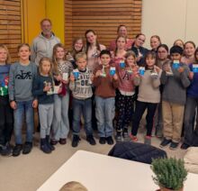 Gruppenfoto von Schüler*innen und Lehrkräften: Es wird zur bestandenen Segelprüfung in der Schule gratuliert.