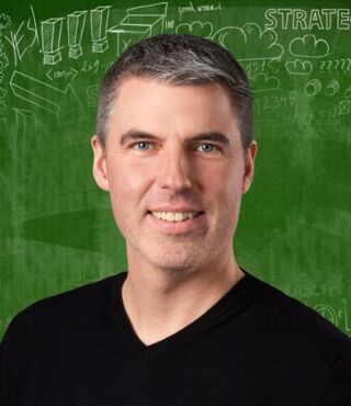Karsten Koppitz - Berufsberatung vor dem Erwerbsleben Ein Portraitbild von einem Mann in einem schwarzen T-Shirt mit V-Ausschnitt. Im Hintergrund ein Scribble auf einer grünen Tafel.