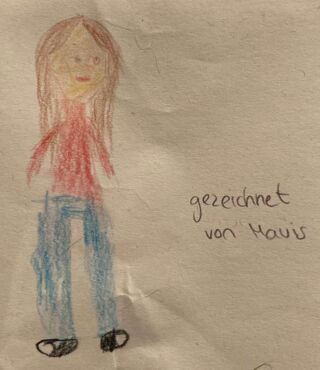 Buntstiftzeichnung eines Kindes, das eine Person mit langen braunen Haaren, rotem Oberteil und blauer Hose zeigt, rechts daneben steht handschriftlich "gezeichnet von Mavis""