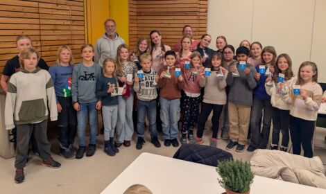 Gruppenfoto von Schüler*innen und Lehrkräften: Es wird zur bestandenen Segelprüfung in der Schule gratuliert.